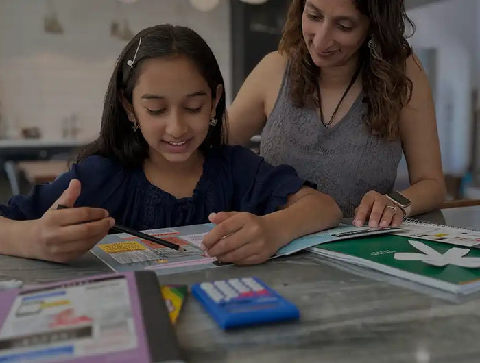 A young girl and woman collaborating on schoolwork.